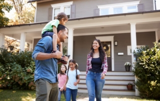 All smiles on the faces of a growing family outside their home