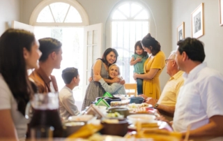 Large family gathers around table for meal in home